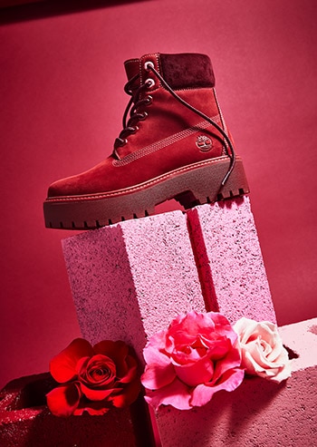 Women's Red 6 Inch Timberland Boot on a cinder block pedestal.